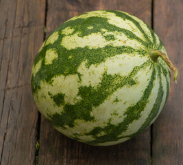 A watermelon on a wooden background close up