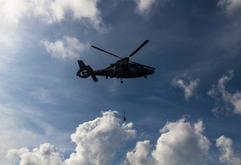 Fototapeta na wymiar Military helicopter flying over clouds. Nato exercise in black sea. 