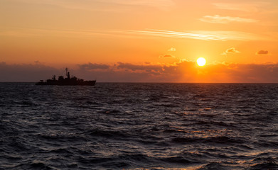 Navy military ship sailing during sunrise at the black sea. Patrol and protect maritime borders.