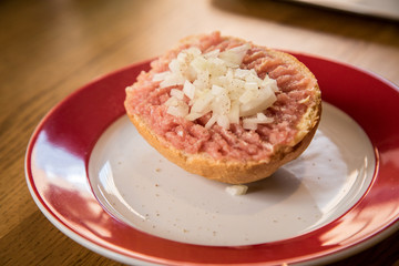 Teller  Mettbrötchen mit Mett und Zwiebeln auf Holz Tisch