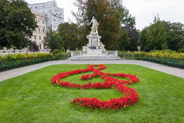 Mozart Statue with flower decoration in the form of a musical treble clef key, Vienna, Austria