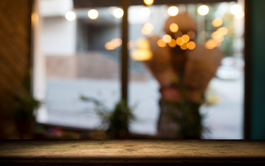 Empty wood table top on blur light gold bokeh of cafe restaurant in dark background