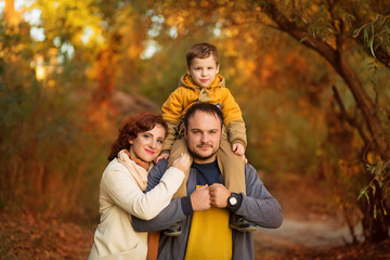 happy family mom dad and son on a walk in the autumn in the park