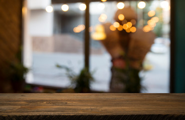 Empty wood table top on blur light gold bokeh of cafe restaurant in dark background