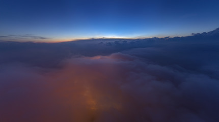 city light from ground visible from above the cloud. noise visible due to low light photography