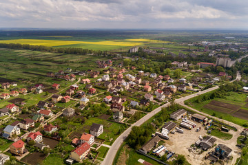 Fototapeta premium Aerial landscape of small town or village with rows of residential homes and green trees.