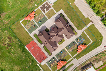 Top aerial view of new prescool building and yard with alcoves and green lawns.