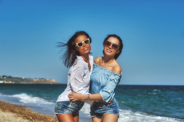 Happy young women at the seaside . Girls in shorts and summer blouses
