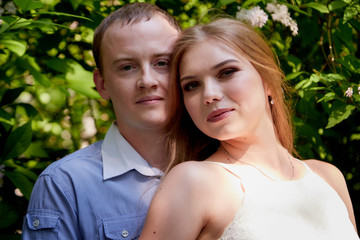 Fototapeta premium Young man and woman couple walk in the park. Spring or summer love story. Young happy family