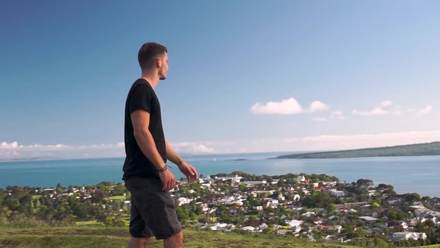 SLOWMO - Young caucasian tourist looking at the ocean from Mount Victoria, Auckland, New Zealand