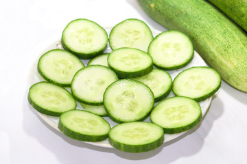 Cucumber slices put on a plate in a white background
