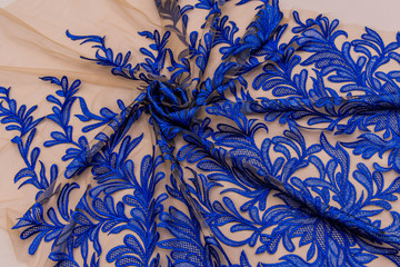 Texture lace fabric. lace on white background studio. thin fabric made of yarn or thread. a background image of ivory-colored lace cloth. Blue lace on beige background.