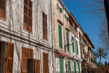 Fototapeta na wymiar Häuserzeile mit bunten Fensterläden in Arta auf spanischer Insel Mallorca
