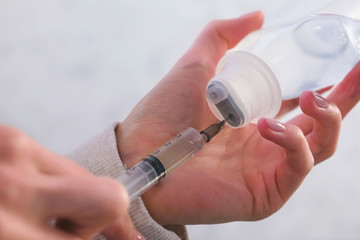 Woman picking up the syringe with saline for inhalation