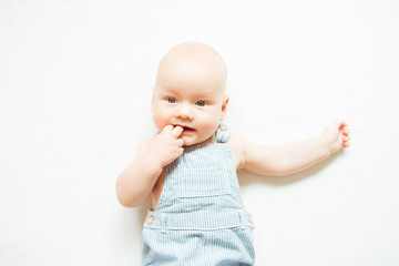 Little baby with finger in mouth on white background
