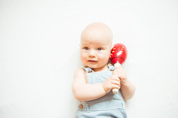 Funny boy baby with musical toy on white background