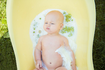 Close up of a baby in milk bath with natural flowers