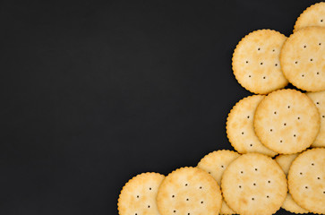 top view stack of round cheese cracker cookies with sugar on black color background with copy space
