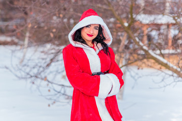 Arabic Santa girl at winter holidays, girl in red costume 