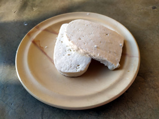 fresh cheese slice put in a plate isolated on stone background