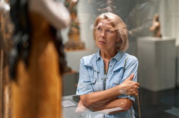 Woman visitor looking art object in art gallery museum.