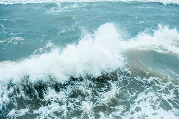 Waves Breaking and Spraying at High Seas and Strong Winds. Storm at the sea in autumn cloudy rainy day.