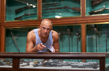 Man visitor in historical museum looking at art object.