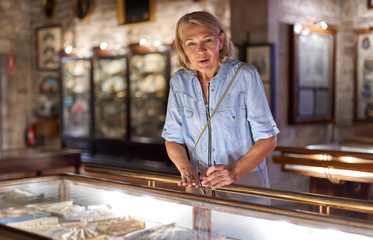 Woman visitor in the historical museum looking at art object.