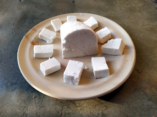 fresh cheese slice put in a plate isolated on stone background