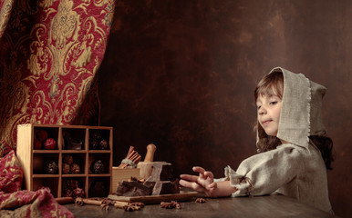 Little girl in an vintage linen dress near the table with sweets.  Genre portrait in retro style.