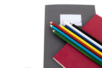 Color pencil and small notebook on white background
