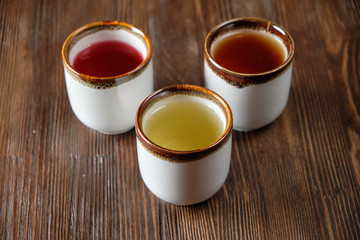 Different tea in teapots on a dark wooden background. catering menu