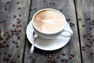 Cappuccino, cup of coffee with milk foam on a wooden background.