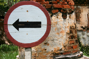 Wooden one way sign with old brick wall background
