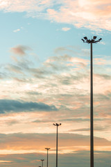 Obraz premium Highway light pole against the blue sky and clouds at sunset.