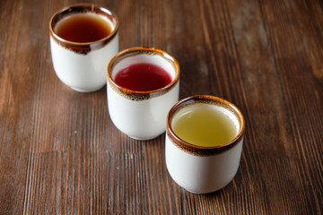 Different tea in teapots on a dark wooden background. catering menu