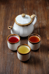 Different tea in teapots on a dark wooden background. catering menu