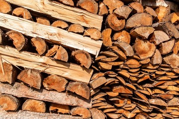 A lot of firewood, natural wooden background. Preparation of firewood for the winter. Stacked Logs Texture, Natural Background. Cross section of the timber.