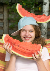 girl with a red slice of watermelon in hands and on her head