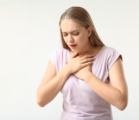 Woman having panic attack on light background