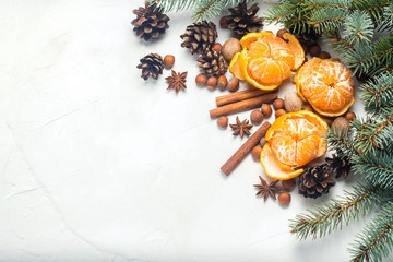 Obraz na płótnie Canvas Mandarins, Christmas tree branches, spices, cinnamon, cones on a white stone background. Concept of Christmas, New Year, Mulled Wine, Winter, Holidays.