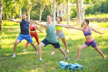 Obraz premium Group of young sporty people training together outdoors