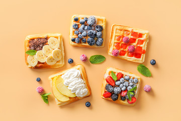 Tasty sweet waffles on color background