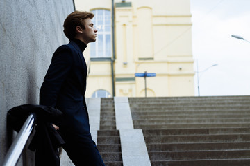 portrait of an attractive young man in a blue suit in the city