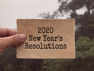 New year resolutions concept - 2020 New Year’s Resolutions written on a paper. Blurred styled background.