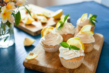 Lemon cupcakes with poppy seeds, white butter cream and  slice of lemon