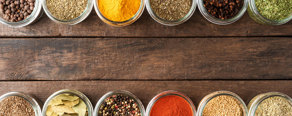 Various types of seasonings in bowls. Collection of seasonings on wooden background  with...