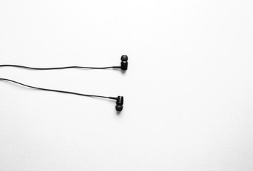 Earphones lying on the pink background. Modern music concept. Audio technology.