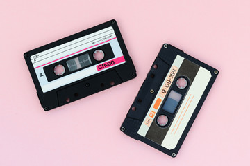 Fototapeta premium Old audio tape cassettes on a pink background. Top view, old technology concept