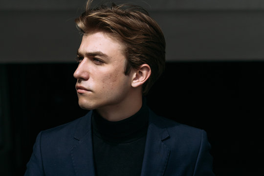 portrait of an attractive young man in a blue suit in the city